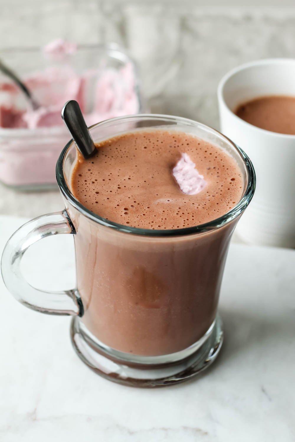 featured image for post showing a mug of raspberry hot chocolate topped with coconut whipped cream
