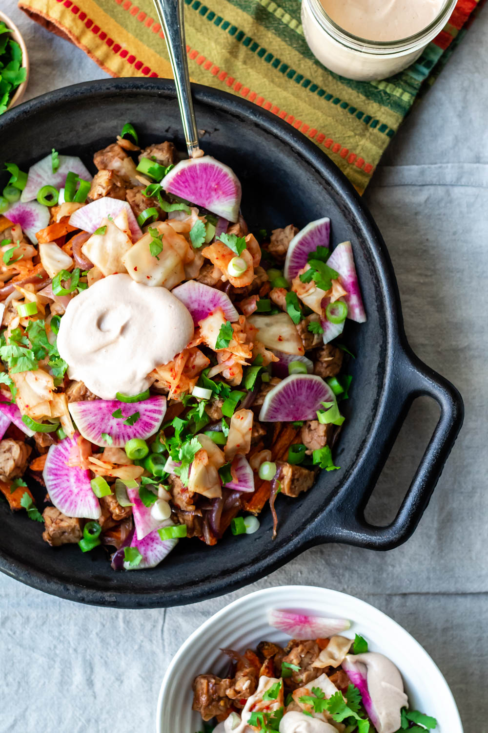 featured image in the post showing an overhead shot of the loaded korean sweet potato fries in a large cast iron skillet