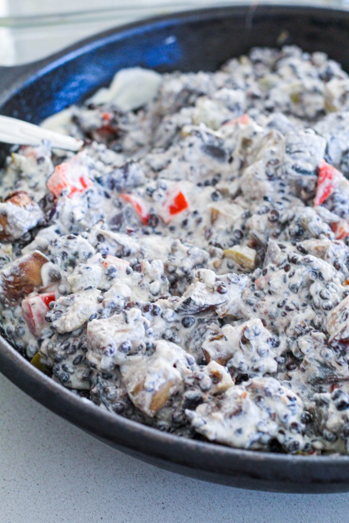 straight on shot of the lentil vegetable cashew cream mixture in a cast iron skillet 