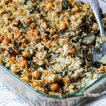 a close up photo of brown rice chickpea casserole in a baking dish