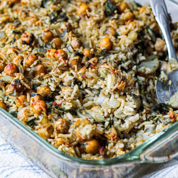 a close up photo of brown rice chickpea casserole in a baking dish