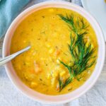 overhead photo of a bowl of the vegan sweet potato corn chowder against a grey backdrop