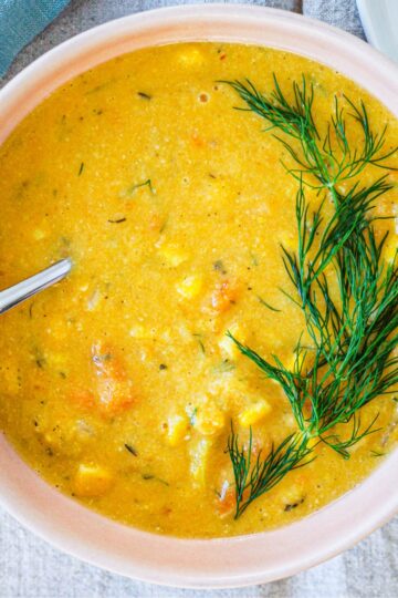 overhead photo of a bowl of the vegan sweet potato corn chowder against a grey backdrop