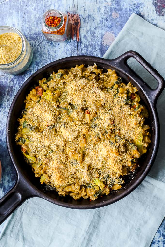 an overhead shot of the Mac and cheese in a cast iron skillet against a blue background 