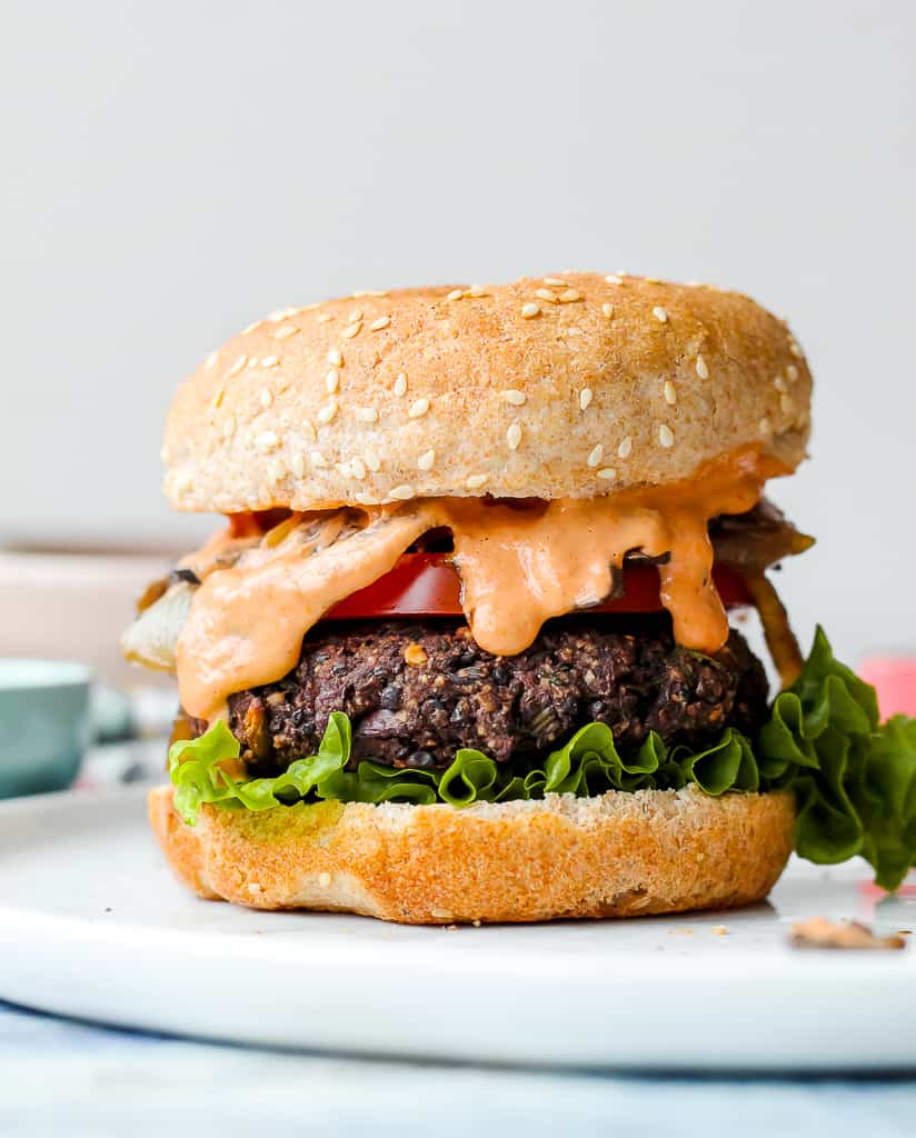 straight on shot of the fully dressed black lentil burger on a bun 