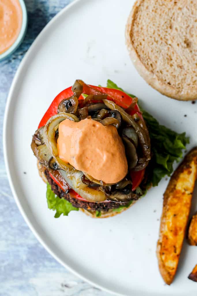 overhead shot of the burger with aioli on it on a white plate 