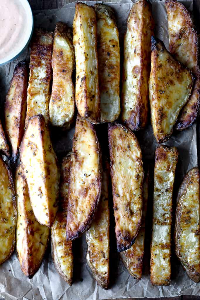 close up overhead shot of the baked fries on a wood tray