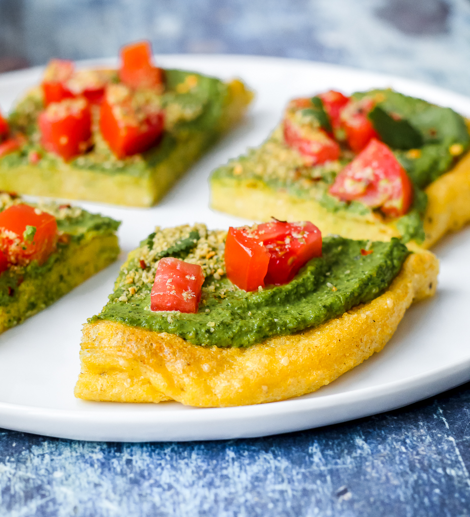 straight on shot of a slice of polenta pizza on white plate 