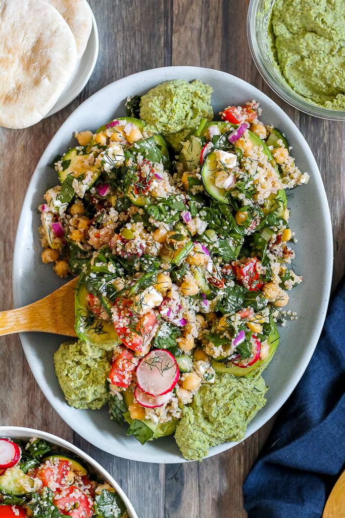 overhead photo of Greek quinoa salad stuffed avocados on a blue platter
