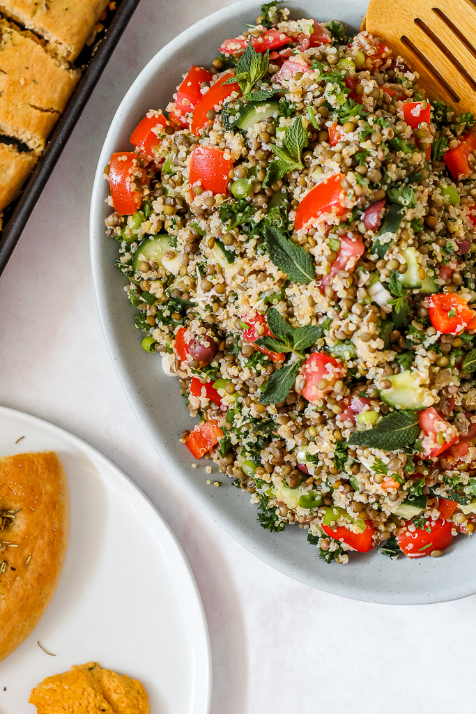 overhead shot of a platter of lentil quinoa tabbouleh and a plate of focaccia 