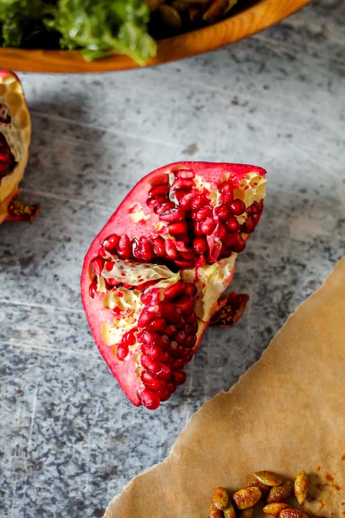 overhead shot of a quarter of a pomegranate on a grey backdrop