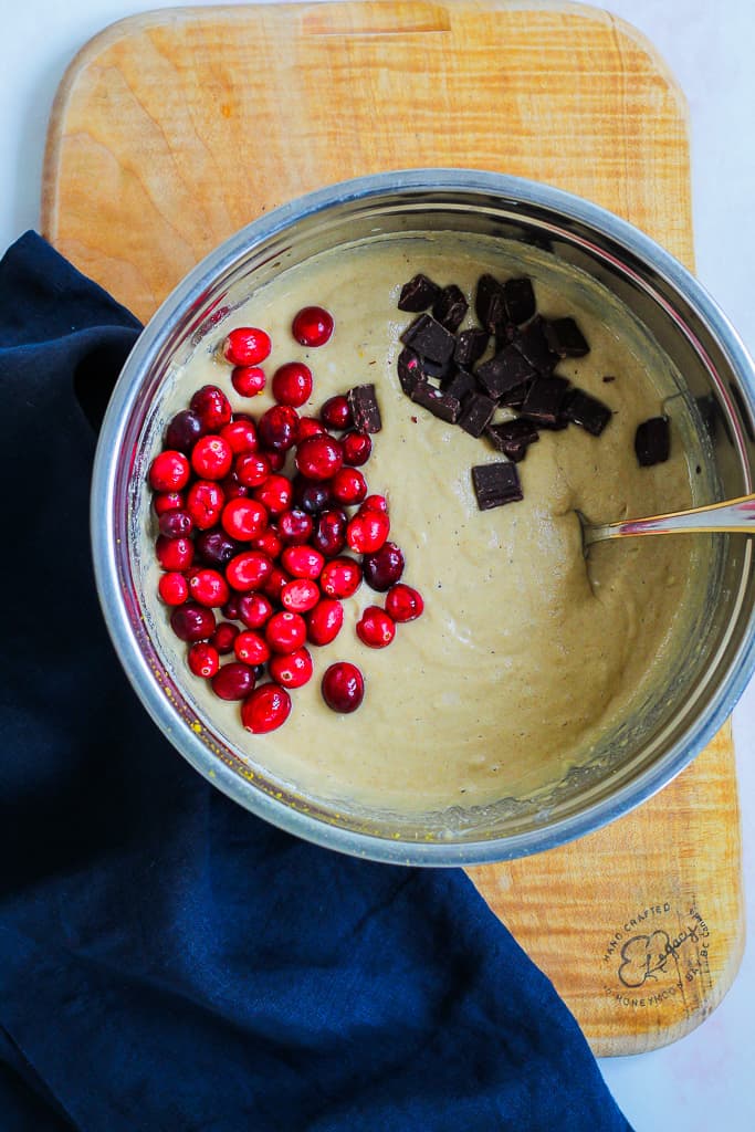 a process shot showing the muffin batter with the cranberries and dark chocolate about to be stirred in