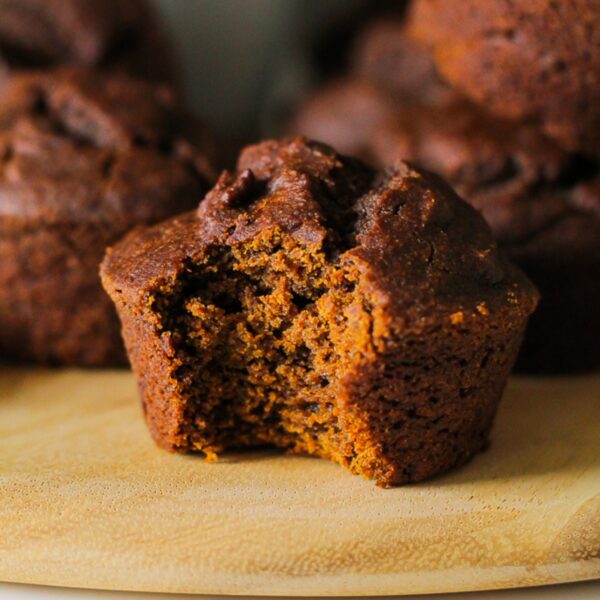 close up photo of a pumpkin gingerbread muffin with a bite taken out of it