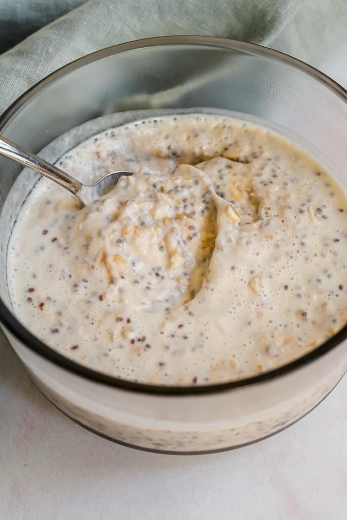 process shot, angled overhead shot of a glass container of the yogurt banana overnight oats