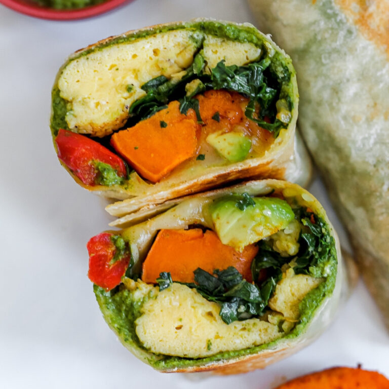1200x1200 pixel featured image for this recipe, an overhead close up photo of an egg and pesto breakfast burrito sliced in half