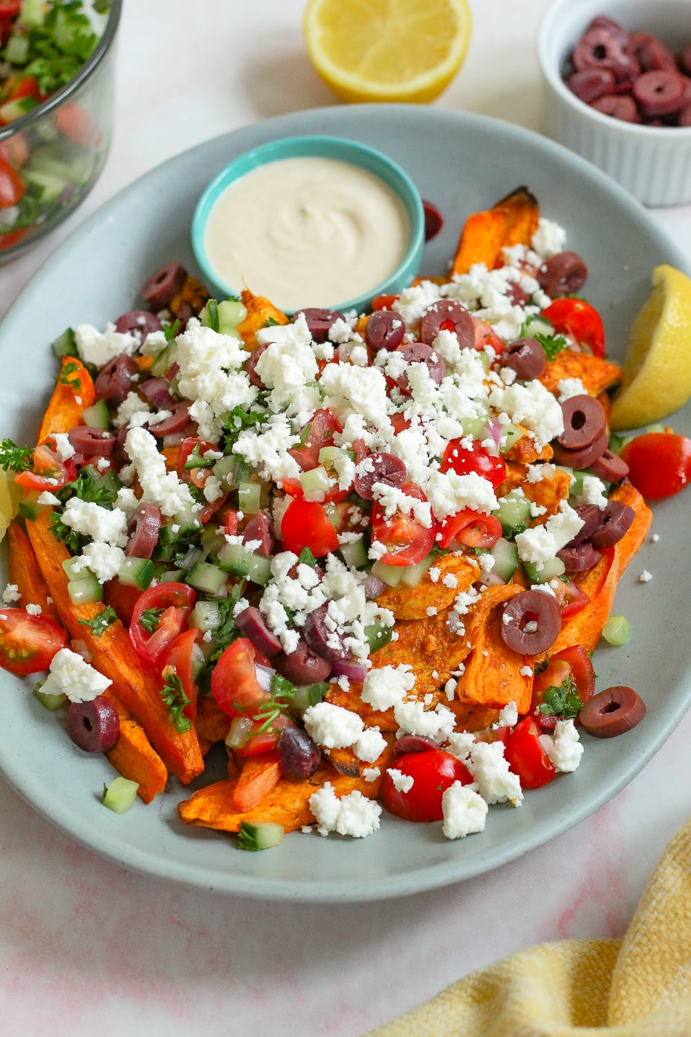 straight on angled photo of the sweet potato chicken shawarma fries on a blue platter