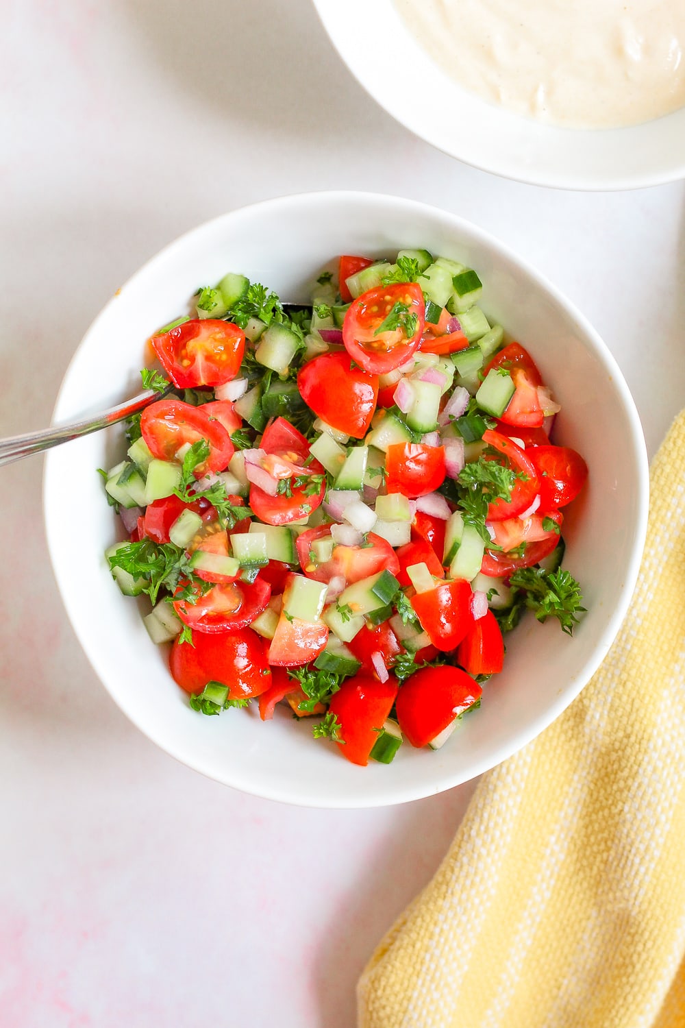 overhead shot of tomato cucumber salsa in a white bowl