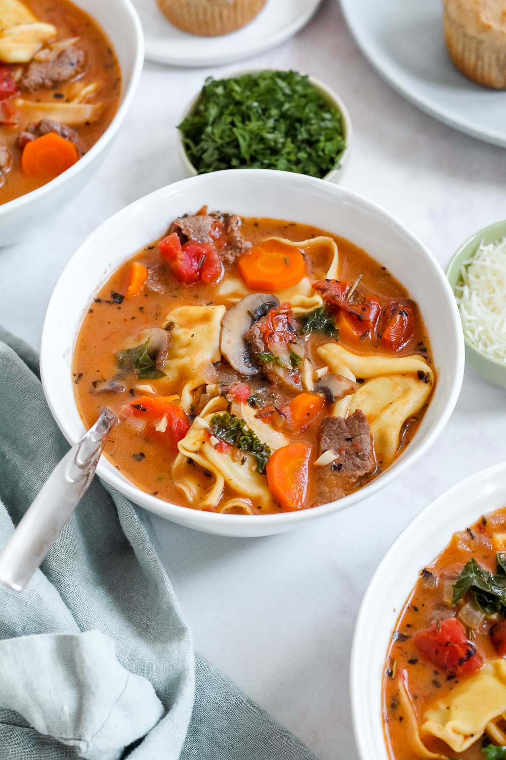 angled overhead shot of a bowl of the soup with beer biscuits in the background