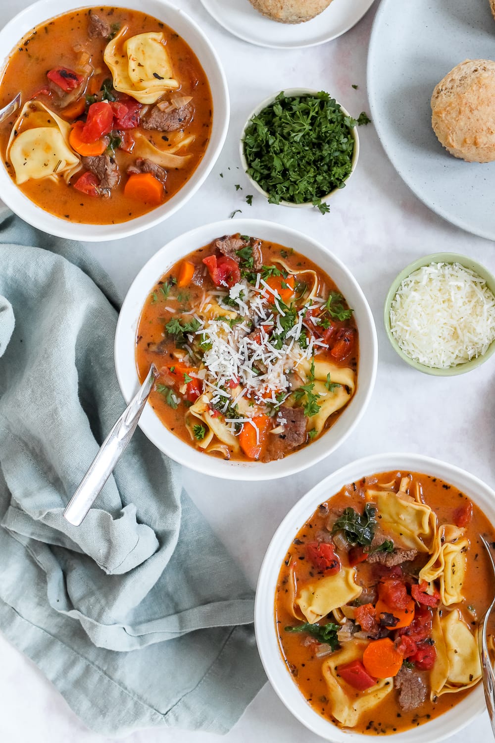 overhead photo of three bowls of spicy beef vegetable soup