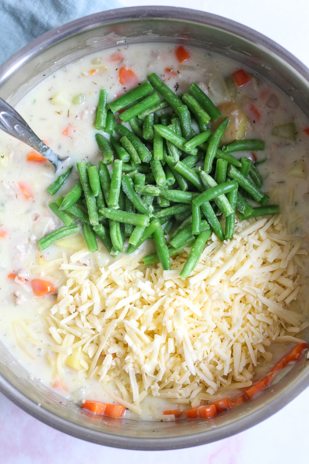 process shot showing the filling ingredients topped with the green beans and cheddar cheese