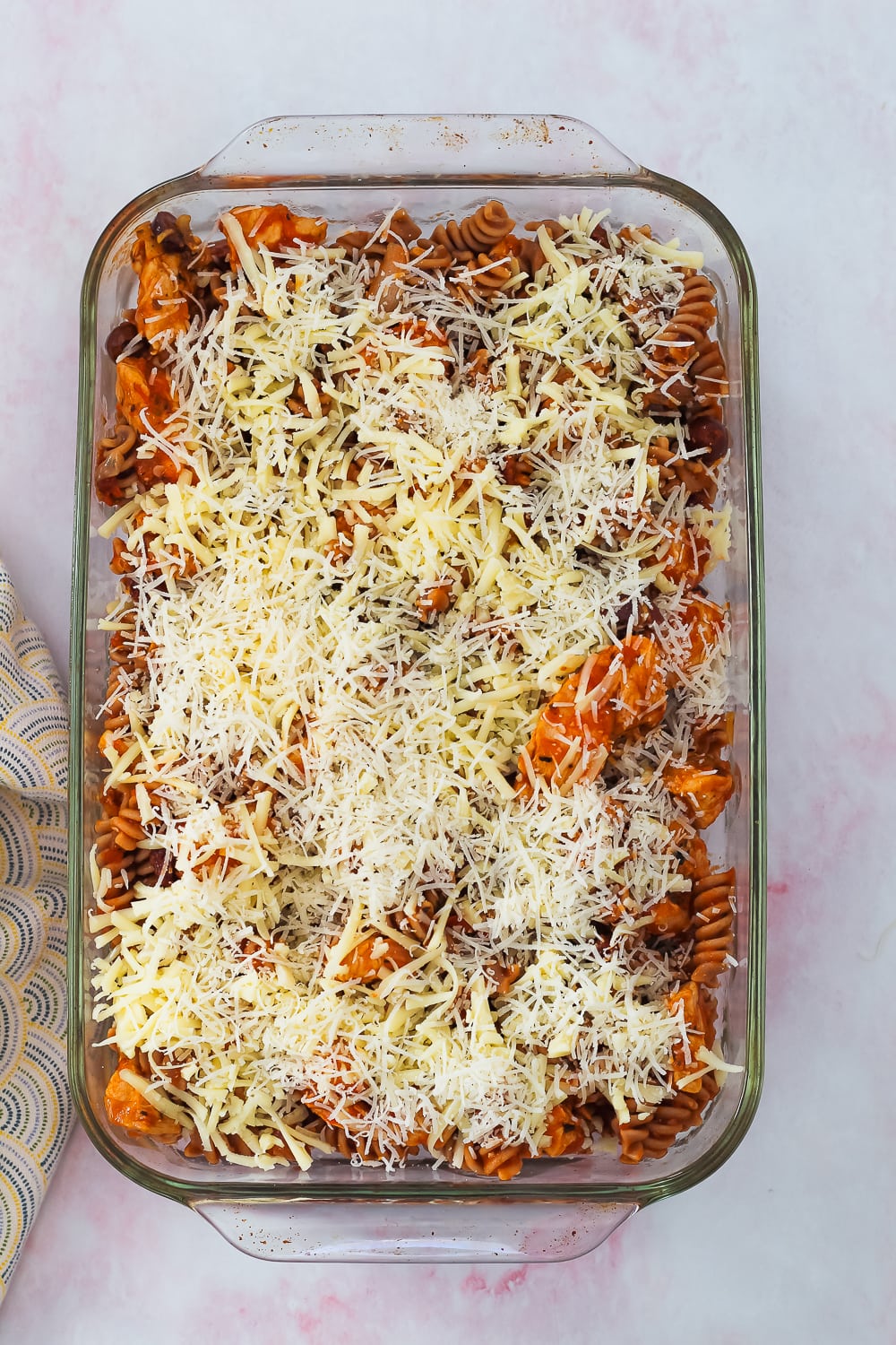 process shot showing the pasta bake in a large baking dish topped with cheese