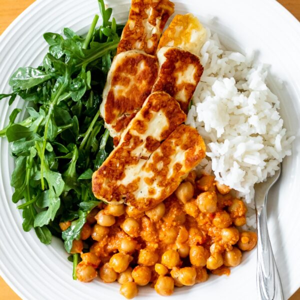 featured image for the post, a photo of a bowl of chickpeas, rice, arugula, and halloumi