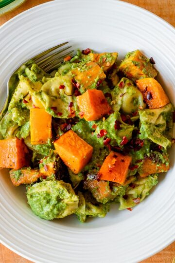 featured image for the post, an overhead photo of a bowl of the tortellini against a wooden board backdrop