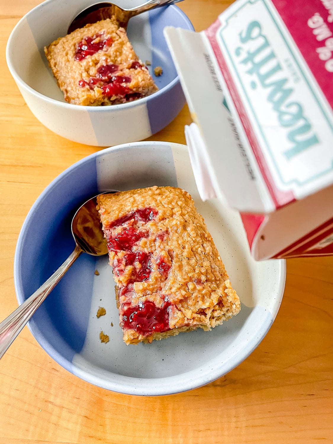 photo of two bowls of the baked oatmeal and milk being poured onto one serving