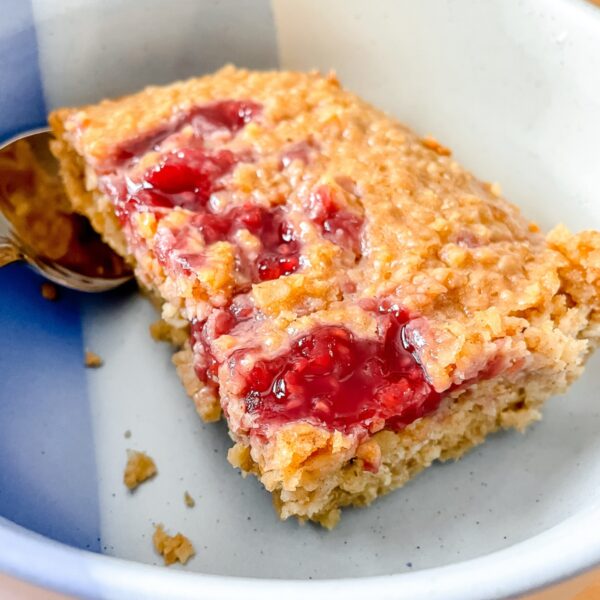 close up photo of a slice of the oatmeal bake in a blue bowl