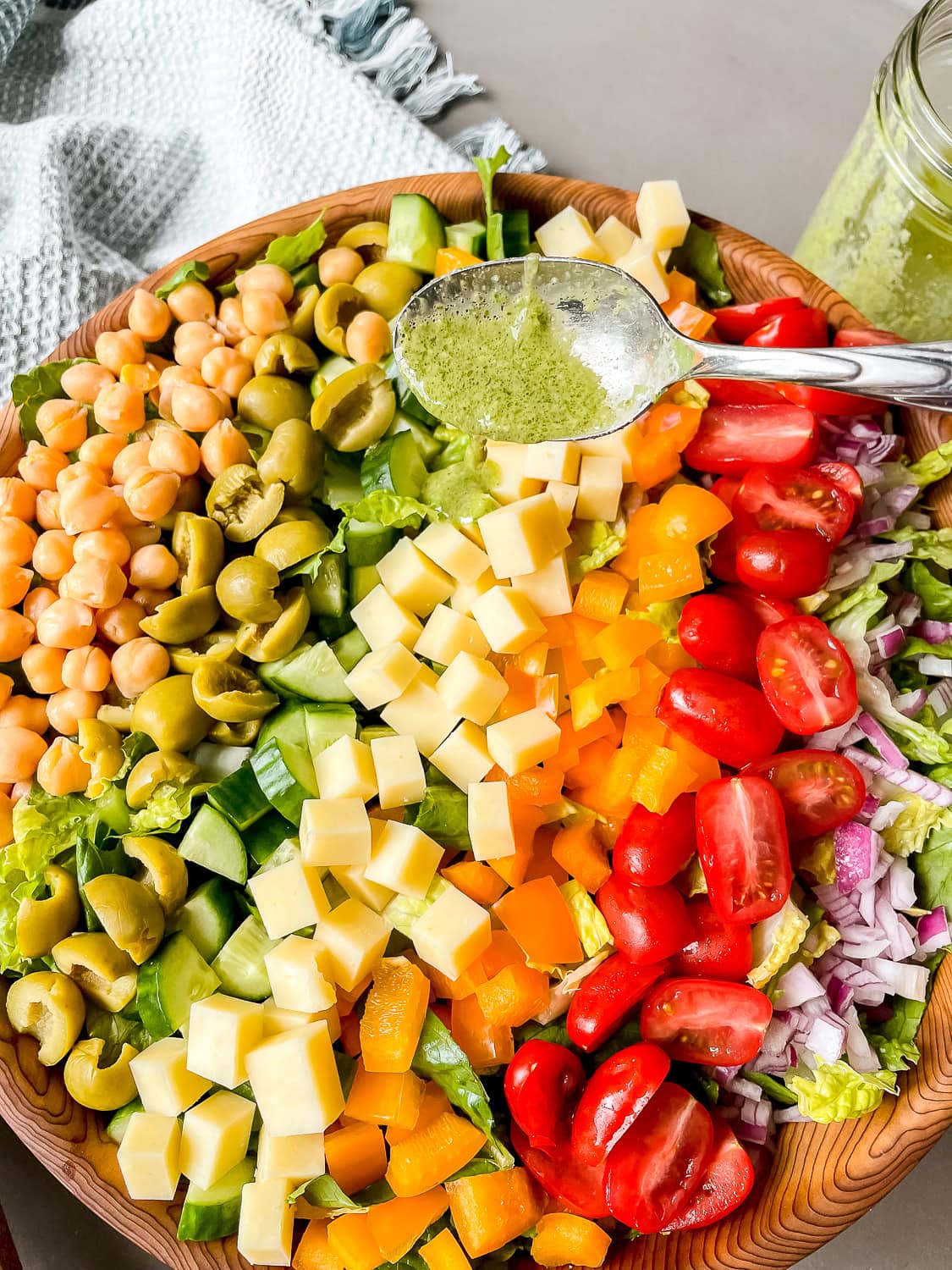 a process photo showing the dressing being drizzled over the salad 