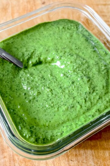 a close up photo of the pesto in a glass container