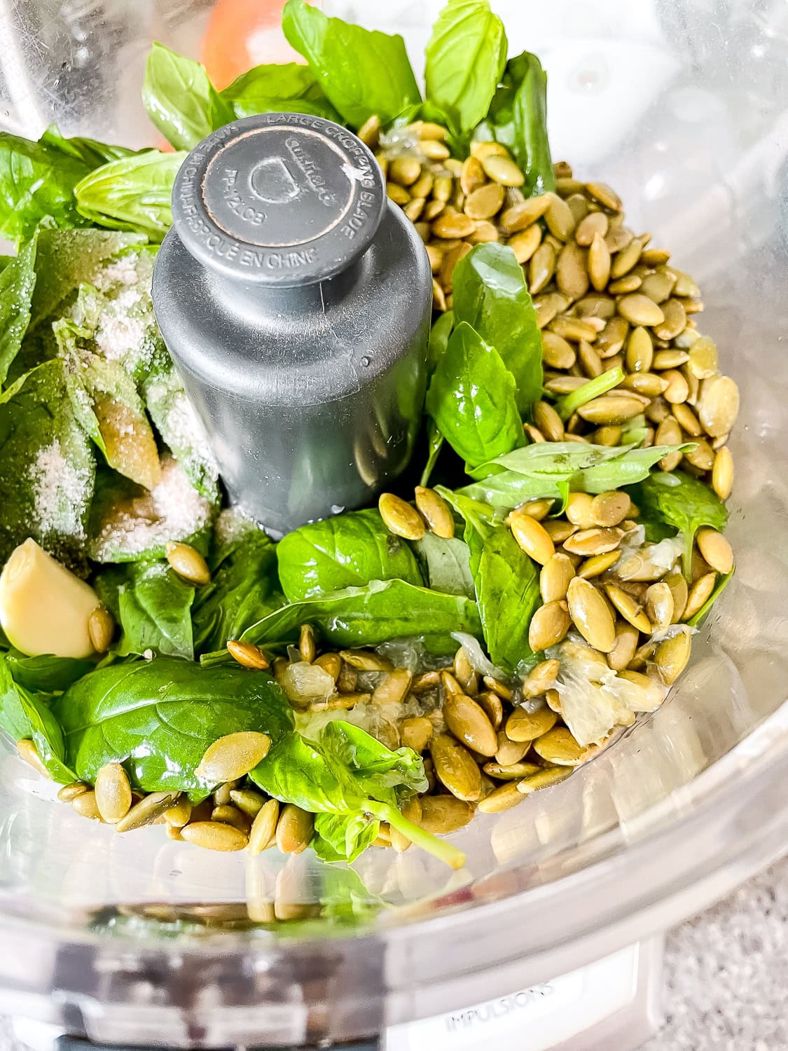 overhead photo of all the pesto ingredients in a food processor