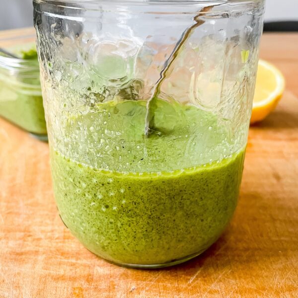 a close up view of the dressing in a glass jar on a wooden board